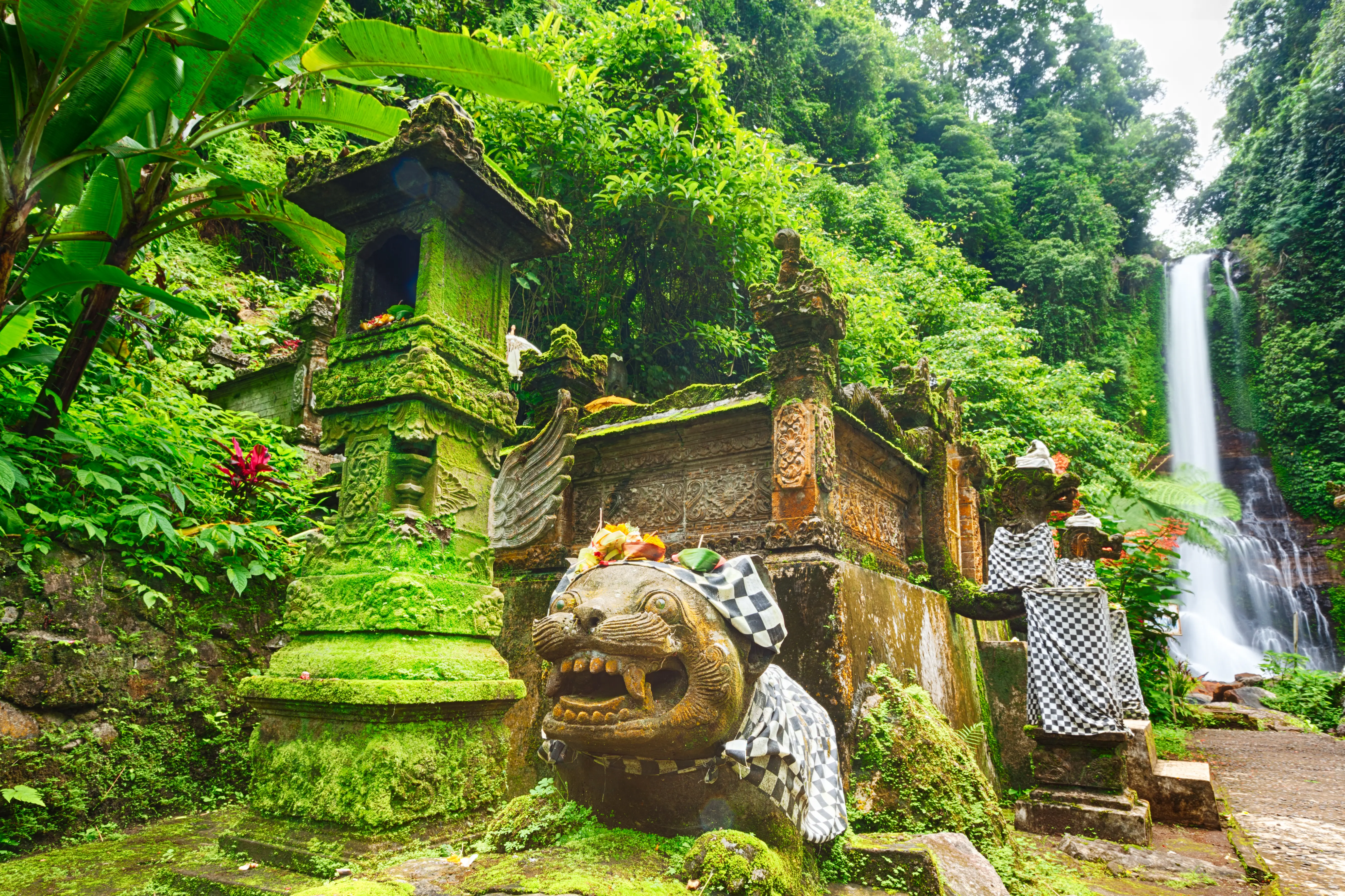 Balinese temple surrounded by tropical forest and waterfall
